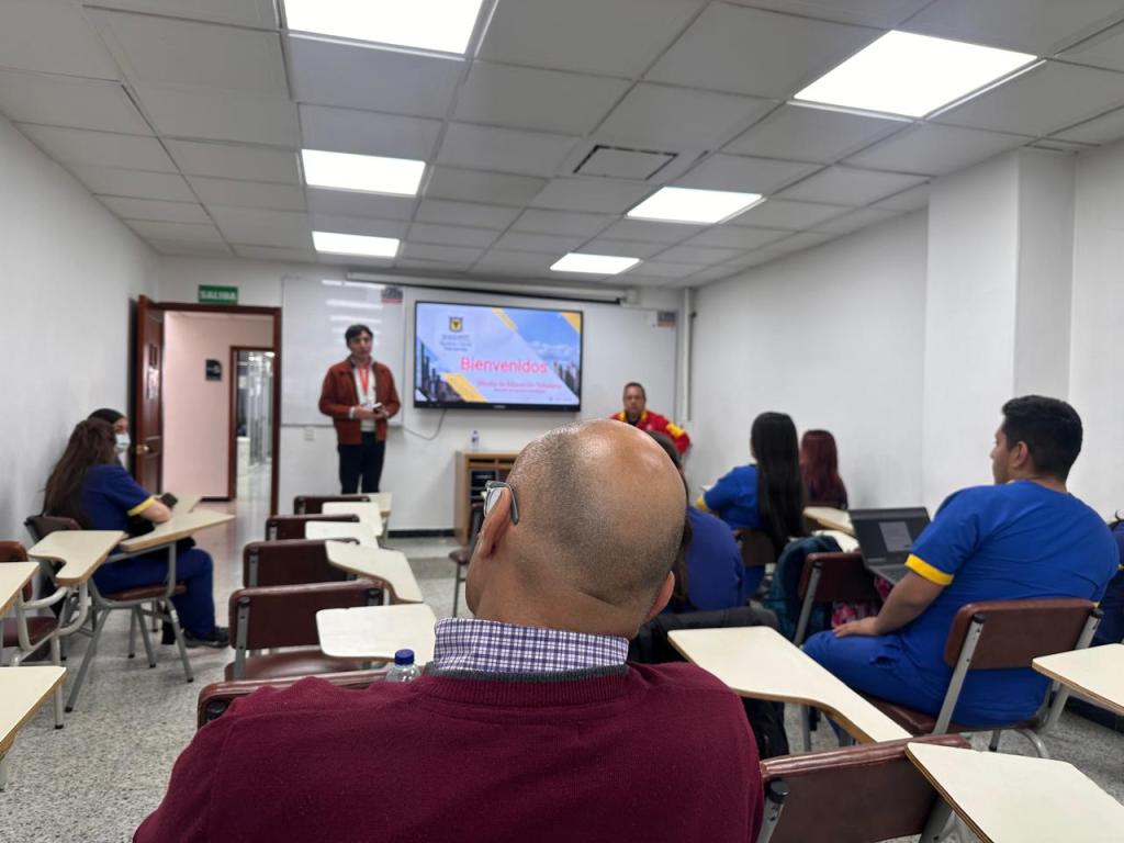 Persona dictando charla a estudiantes 