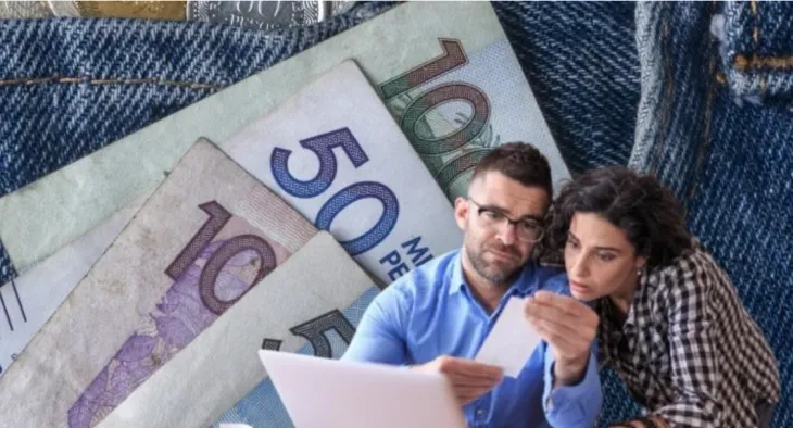 Fotomontaje hecho por El Tiempo con imagen de billetes de pesos colombianos y una pareja miendo información en un computador portatil